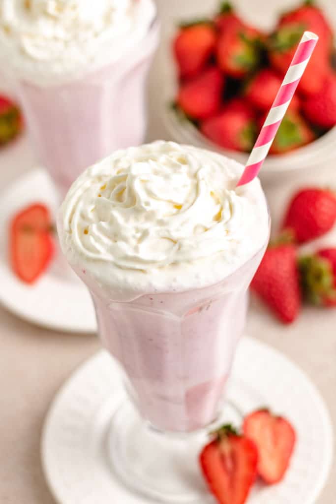 Whipped cream on top of strawberry shakes.
