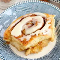 Cinnamon roll on a blue and white plate.