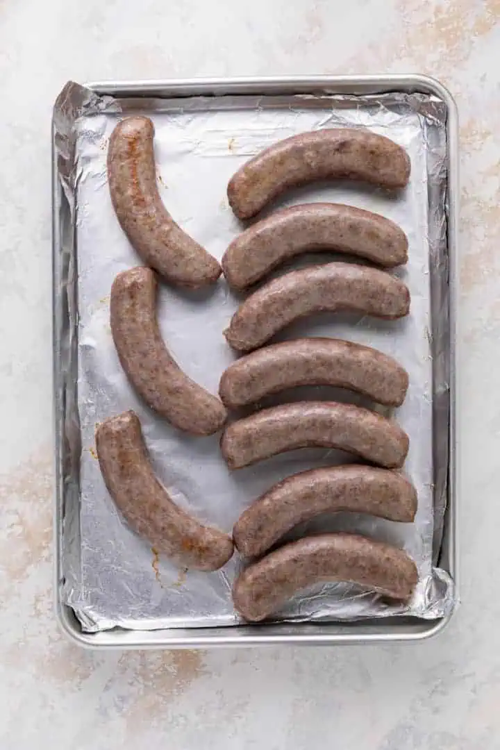Brats baking on a pan.
