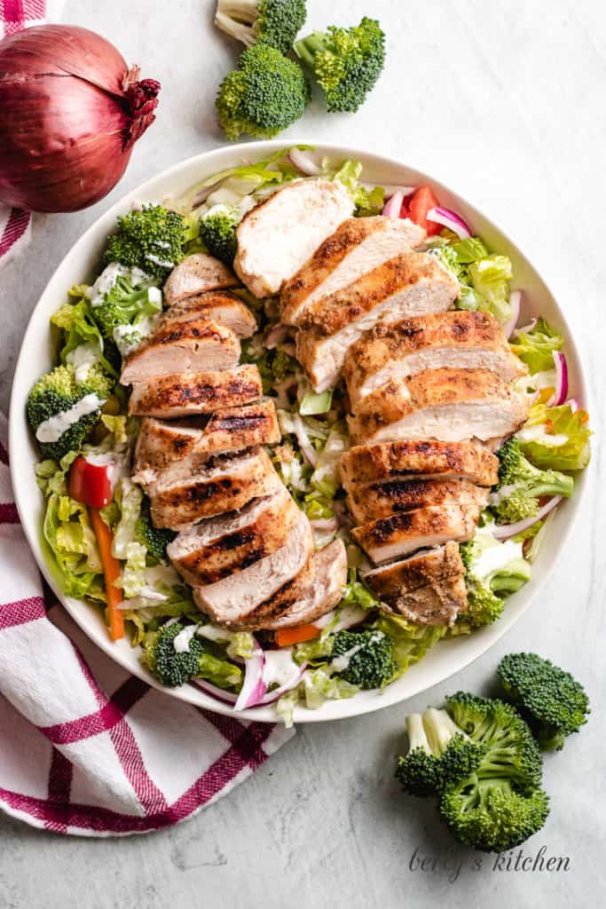 Top down view of grilled chicken salad in a bowl.