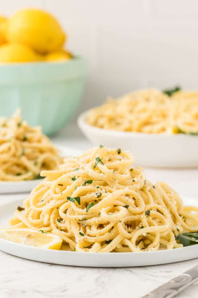 Plates of lemon spaghetti with basil.