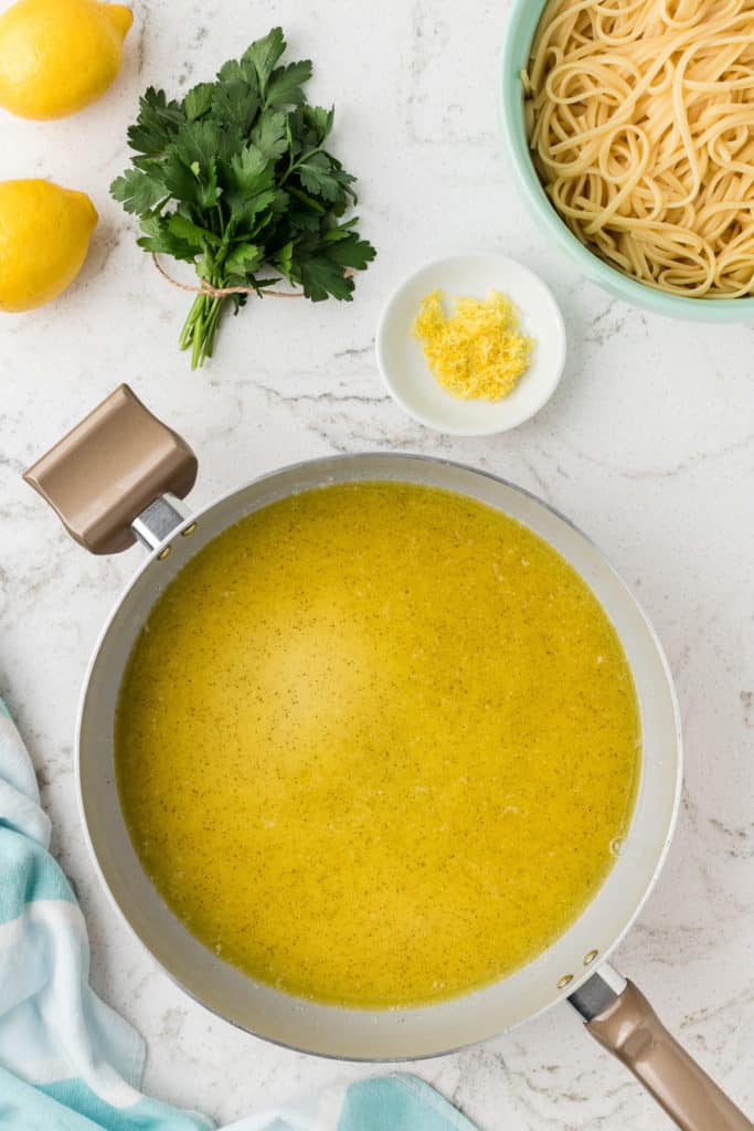 Lemon, cheese, butter, oil, and pepper in a pan.