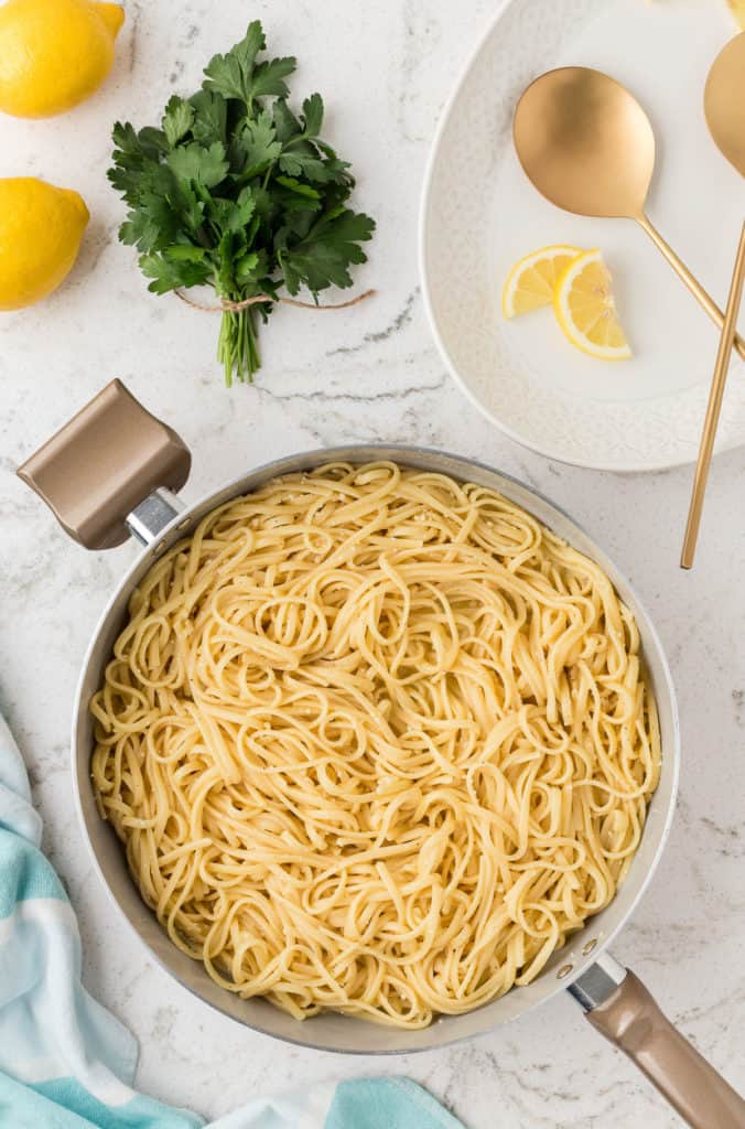 Cooked noodles added to lemon butter sauce.