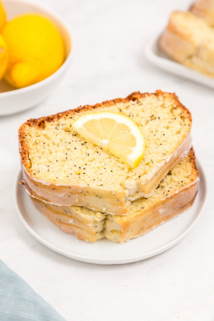 Lemon slice on two pieces of lemon poppy seed bread.