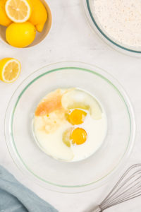 Milk, eggs, canola oil and vanilla extract in a bowl.