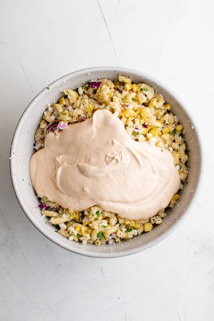 Spicy dressing poured over pasta salad.