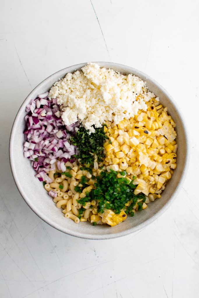 Corn, queso fresco, jalapeño, onion and cilantro in a bowl.