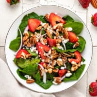 Top down view of strawberry spinach salad with goat cheese.