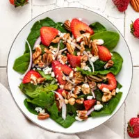 Top down view of strawberry spinach salad with goat cheese.