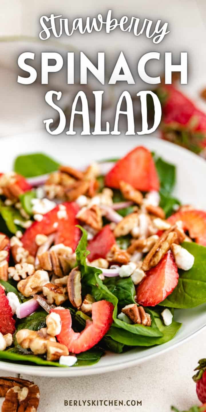 Close up view of a large bowl of spinach strawberry salad.