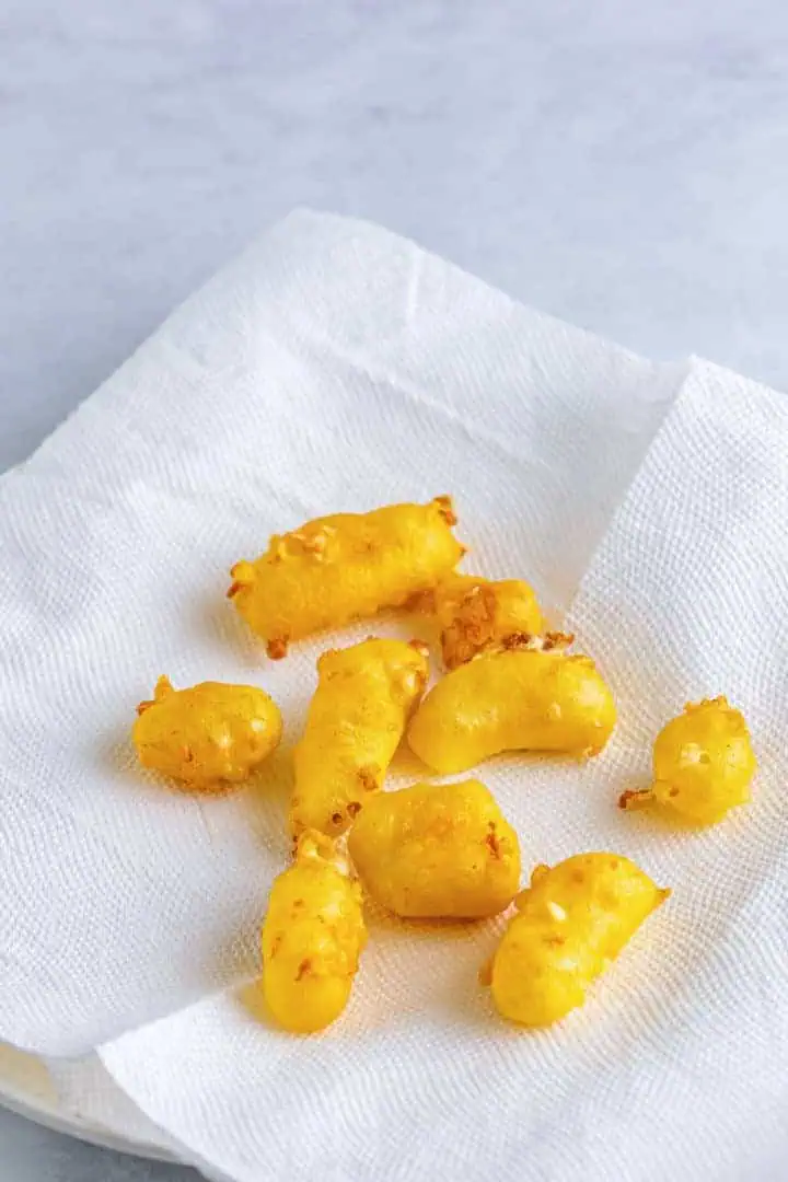 Fried cheese curds drying on a paper towel.