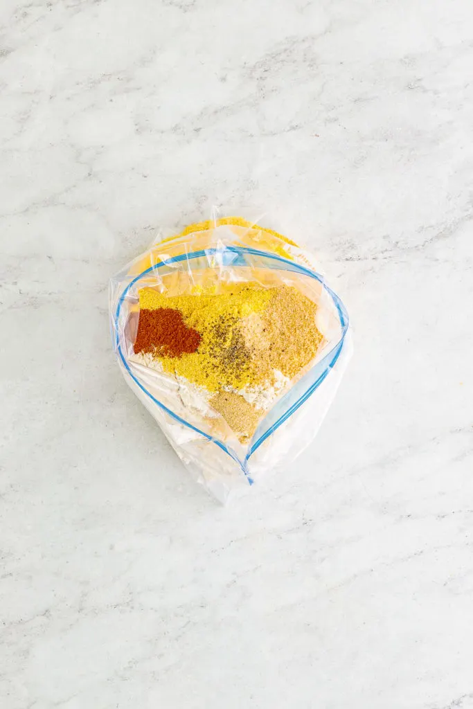Cornmeal and spices in a plastic bag.