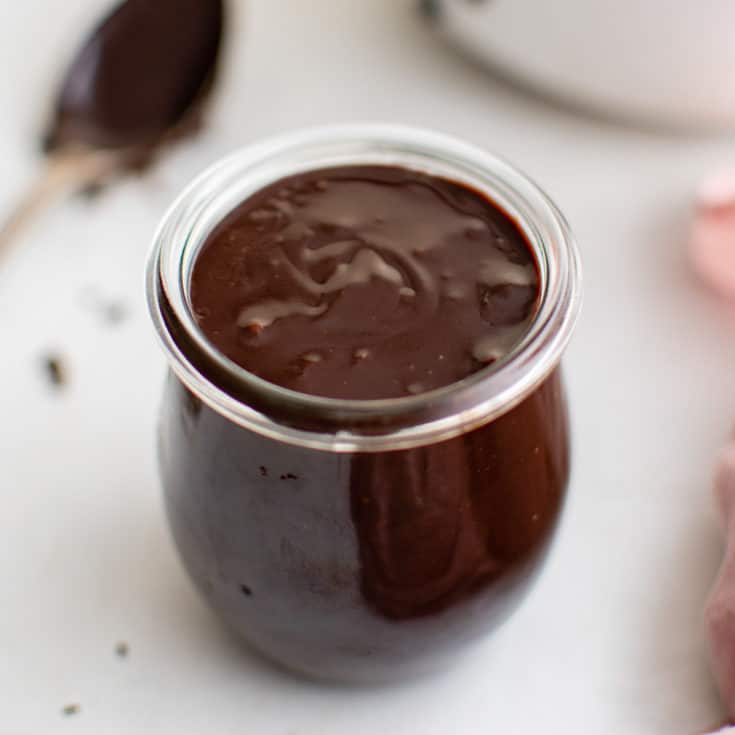 Small jar filled with hot fudge.