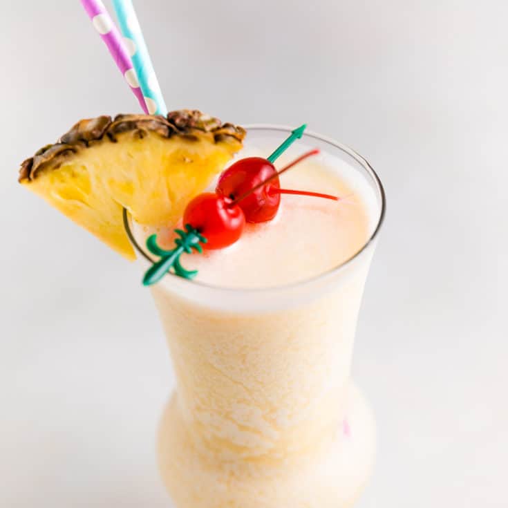 Cocktail with straws and a pineapple.