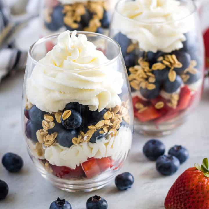 Whipped cream and granola layered in a fruit parfait.