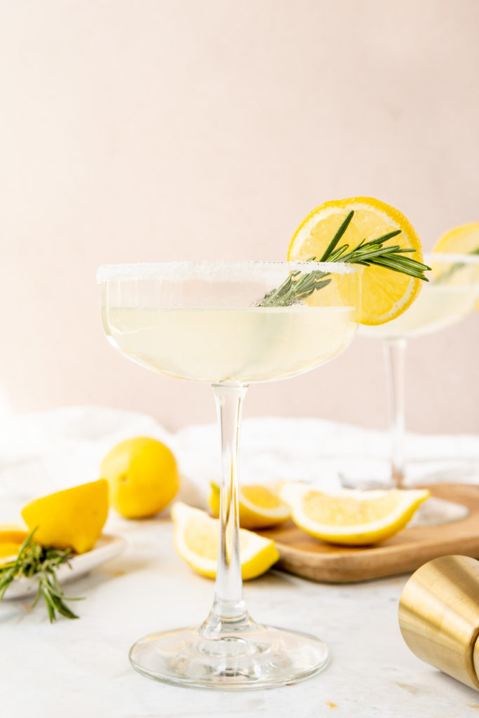 Cocktail with lemon and rosemary in a glass.