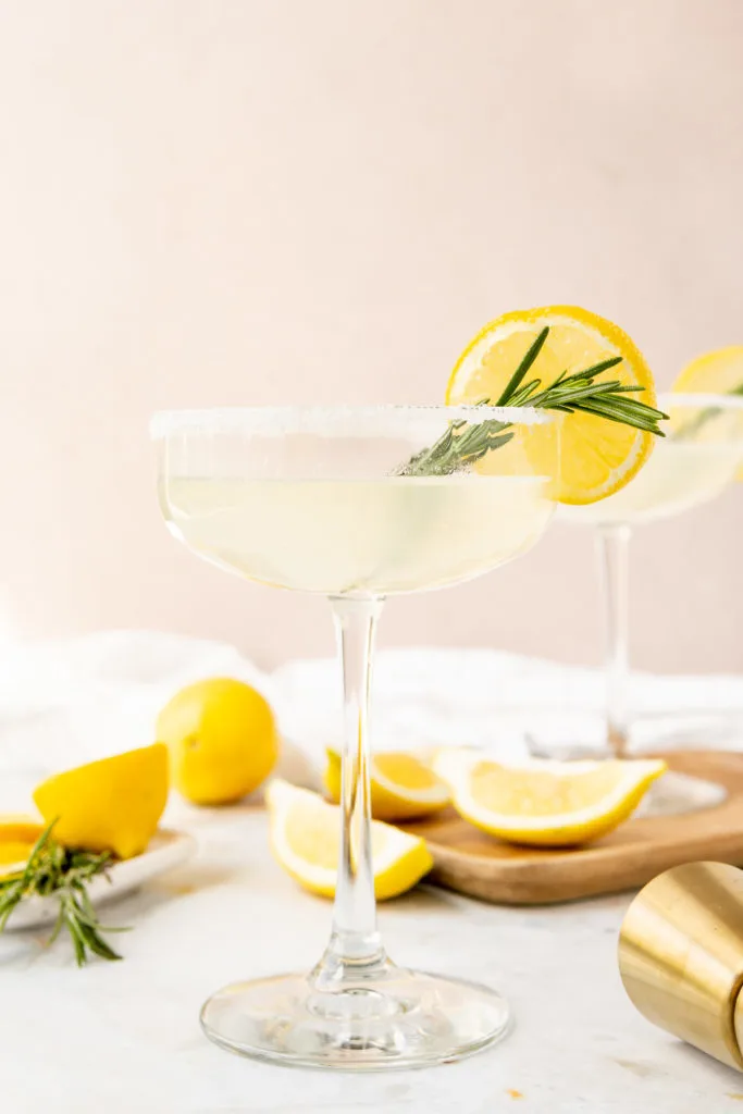 Cocktail with lemon and rosemary in a glass.