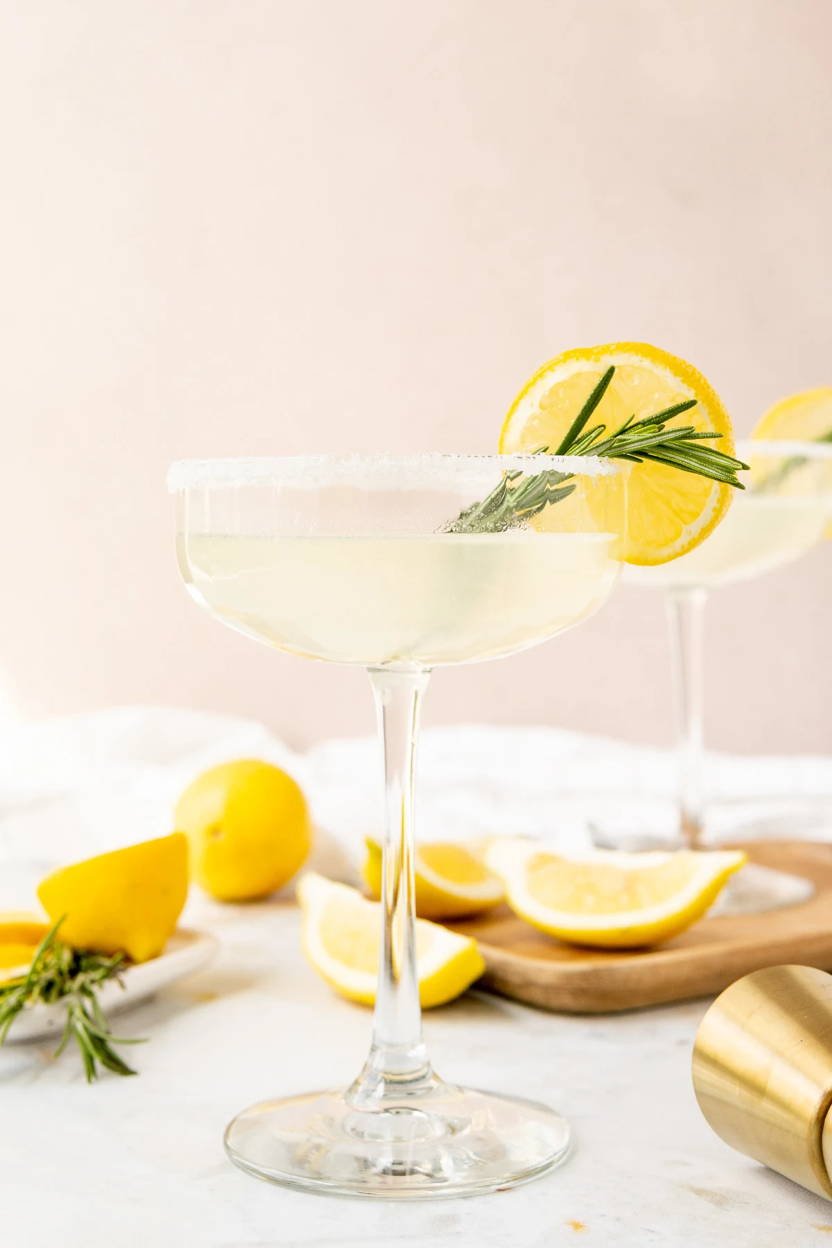 Cocktail with lemon and rosemary in a glass.