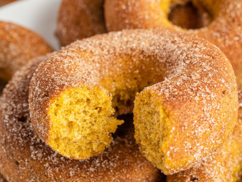 Bite taken out of a baked pumpkin donut.