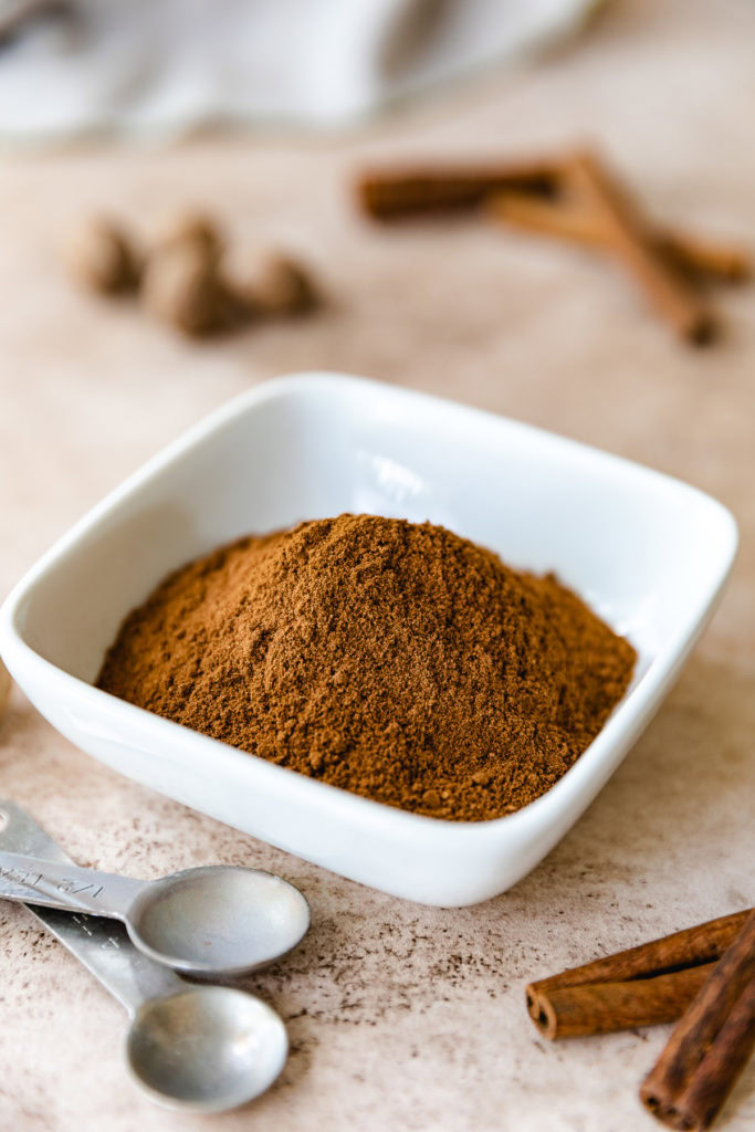 White dish filled with apple pie spice seasoning.