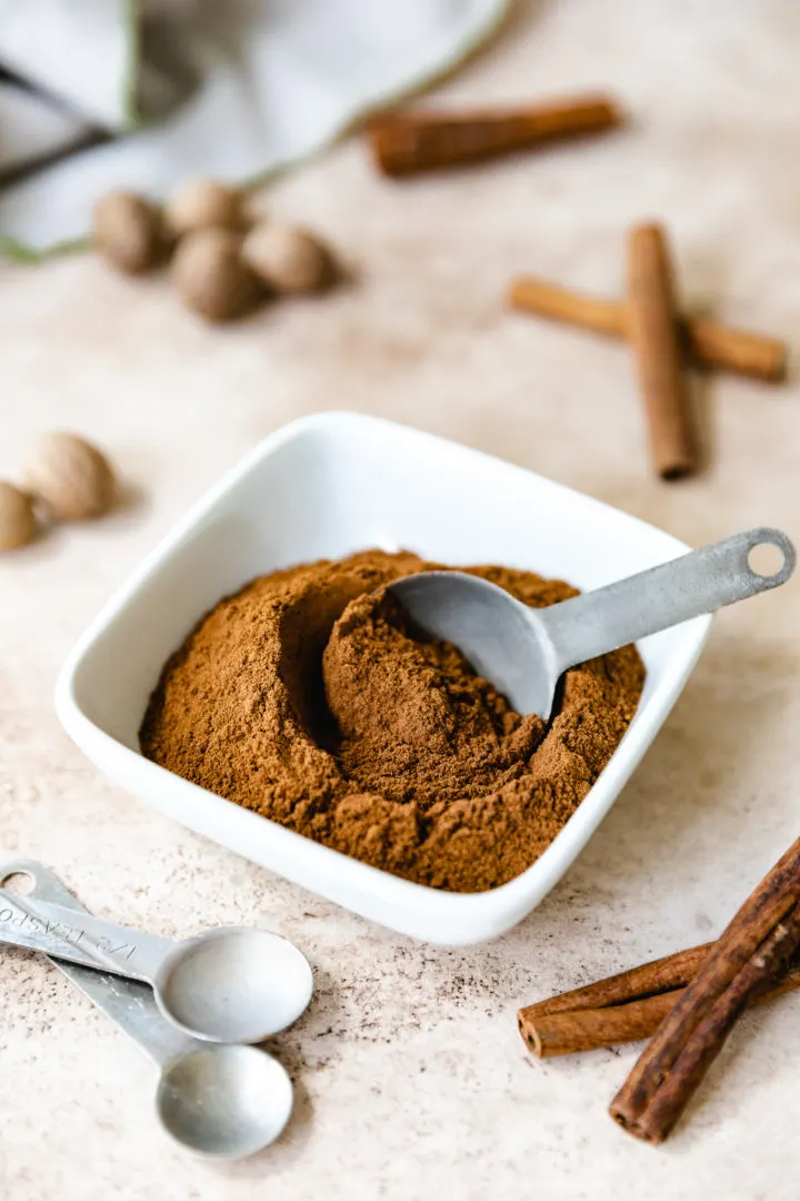 Apple Pie Spice Measuring spoon in a bowl of spices.