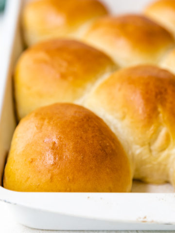 Freshly baked rolls in a white pan.