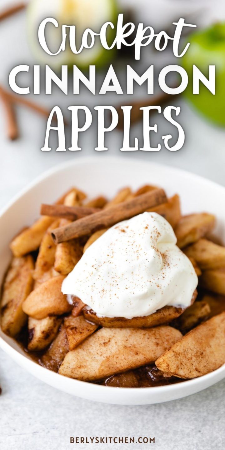 White bowl filled with slow cooker cinnamon apples and whipped cream.