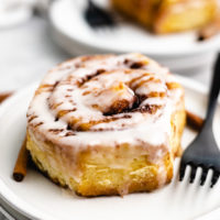 Close up view of an iced cinnamon bun on a plate.