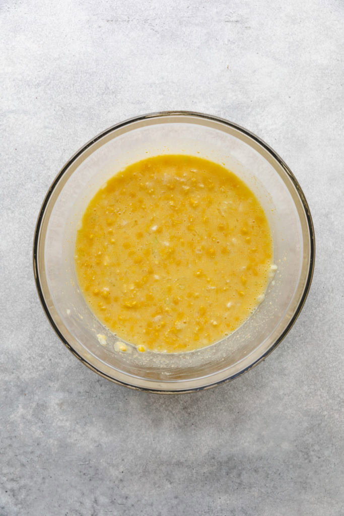 Creamed corn, eggs, and onions in a bowl.