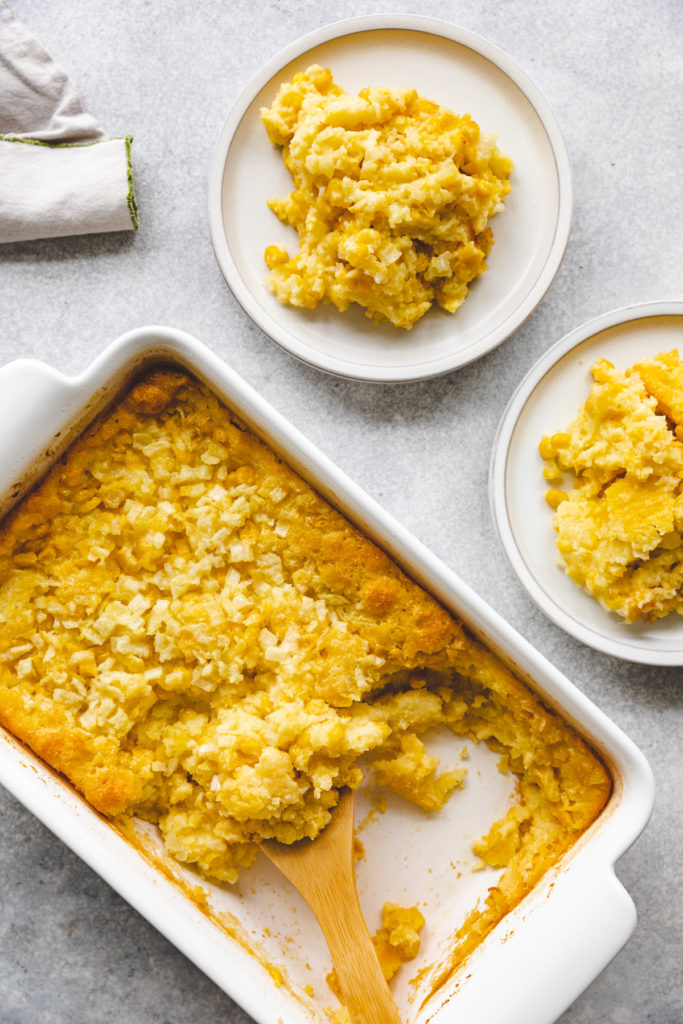 Corn casserole being scooped from a pan.