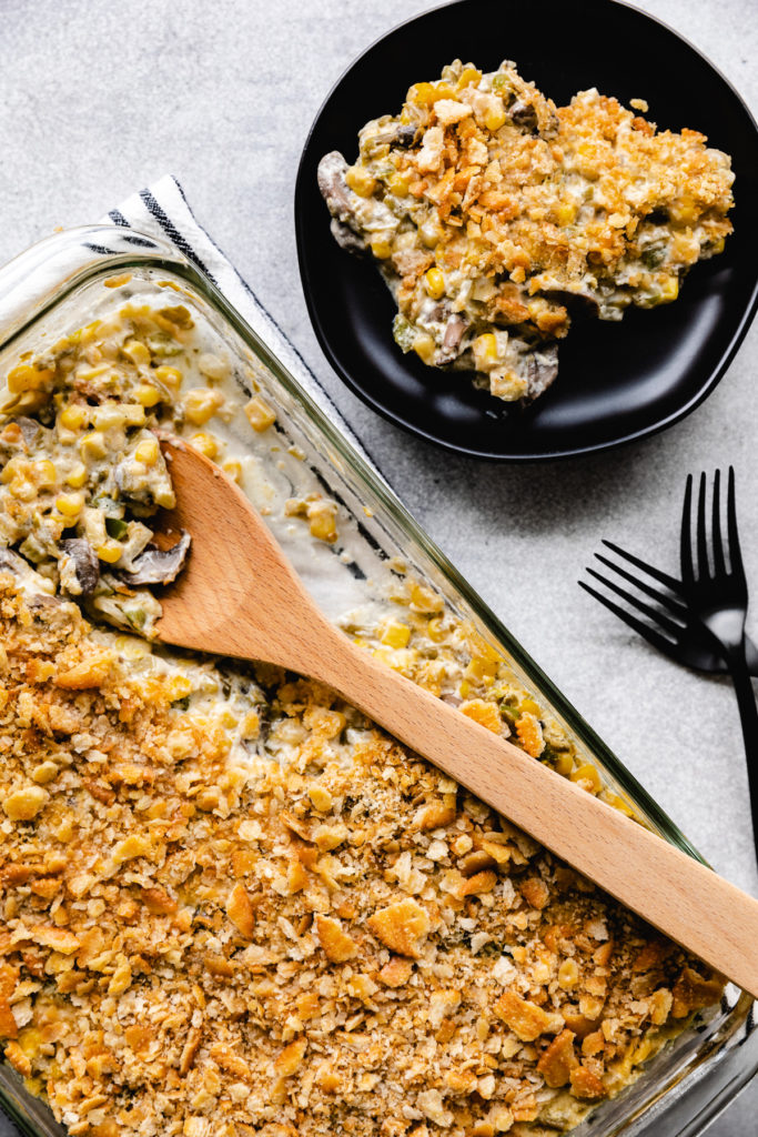 Green bean and corn casserole being scooped from a pan.