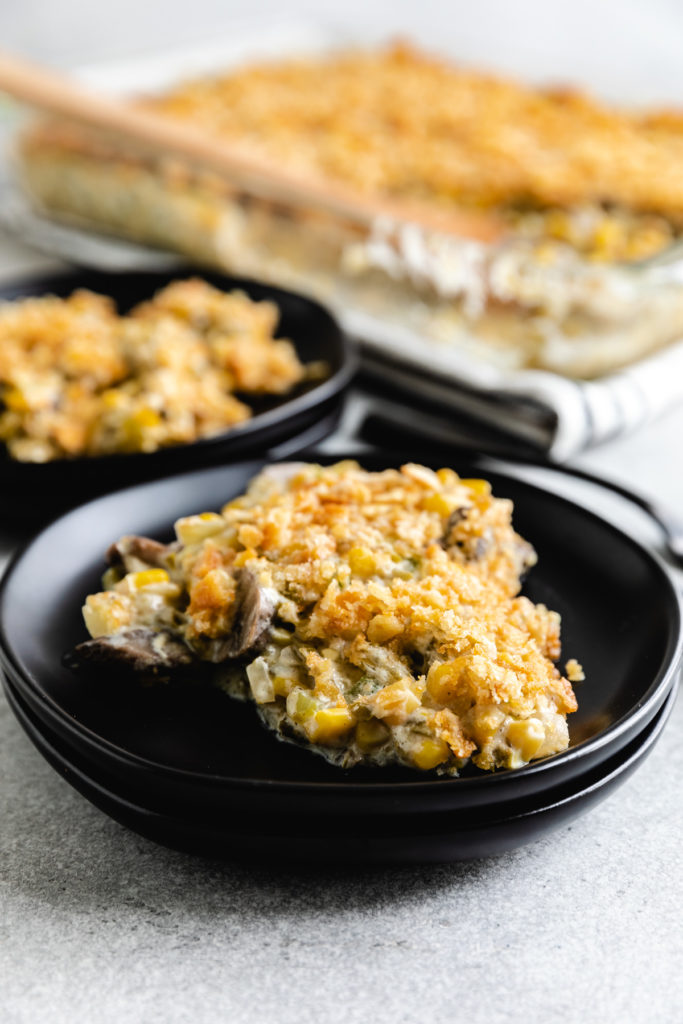 Side view of a scoop of green beans and corn casserole on a plate.