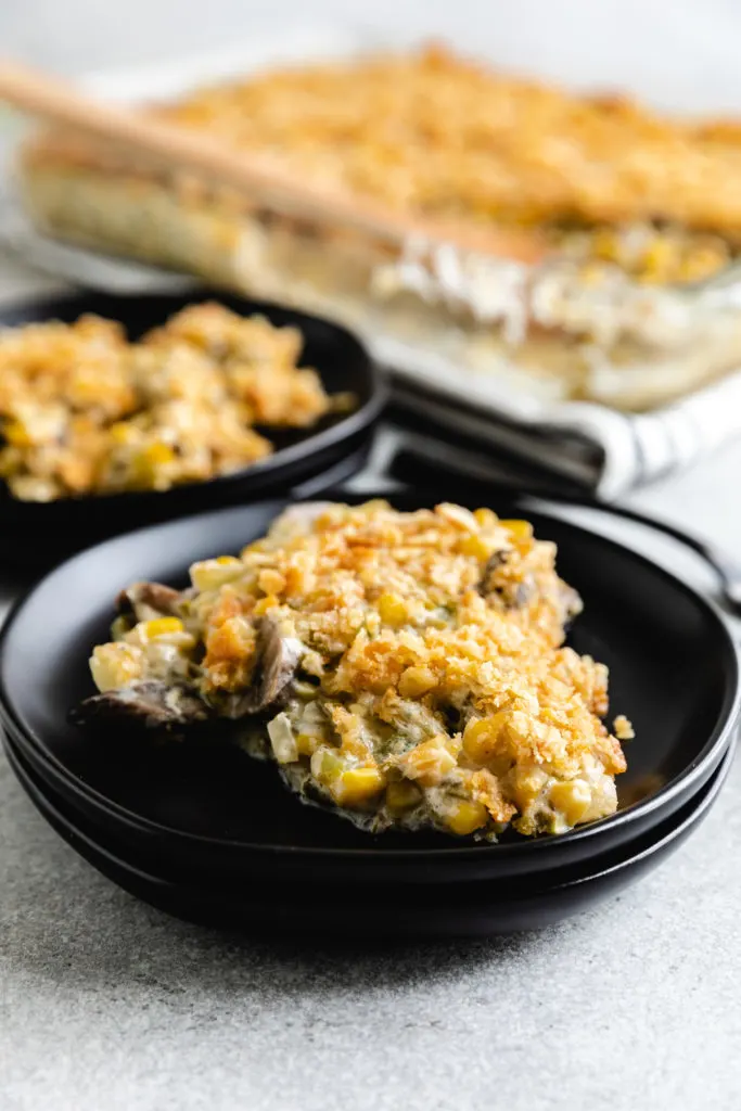 Side view of a scoop of green beans and corn casserole on a plate.