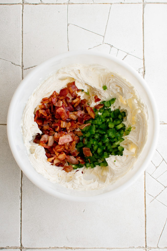 Cream cheese, jalapenos and bacon in a bowl.