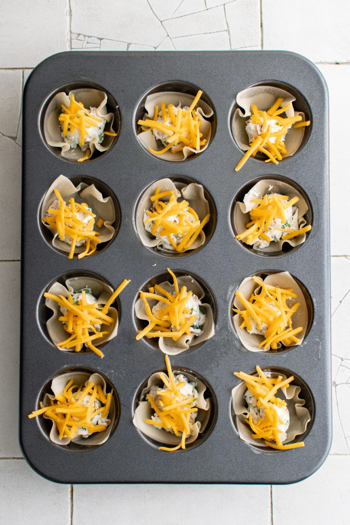 Cheese sprinkled over cream jalapeno cups.