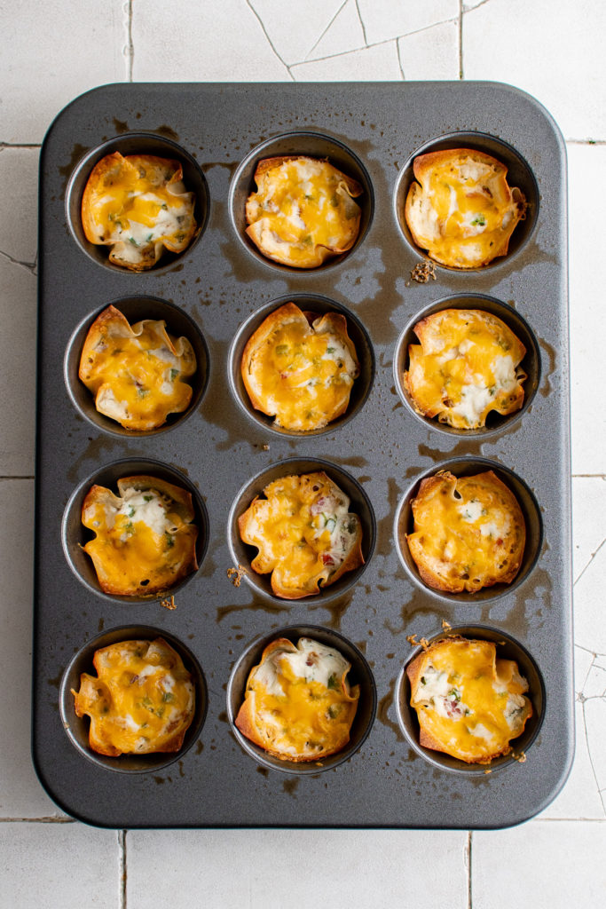 Baked jalapeno cheese cups in a muffin pan.