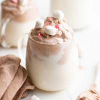 Close up view of whipped hot chocolate in a glass.