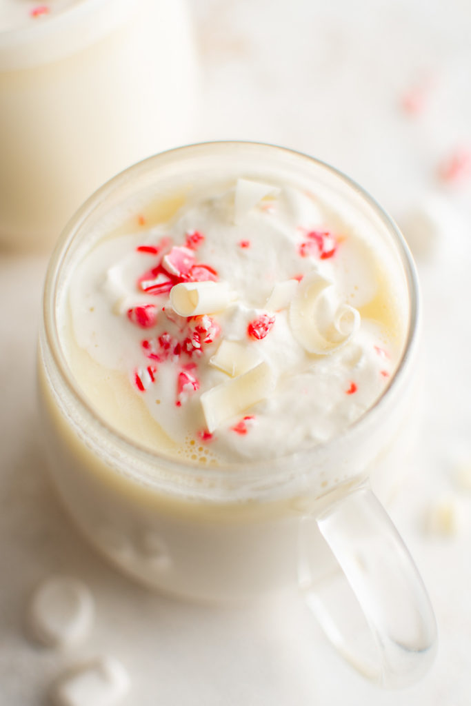 Peppermint and marshmallows in a cup of white hot chocolate.