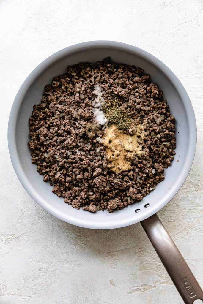 Ground beef in a skillet with seasonings.