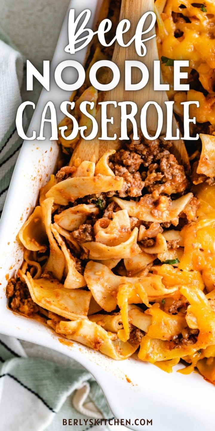 Close up view of beef, noodles, cheese and sauce in a casserole dish.
