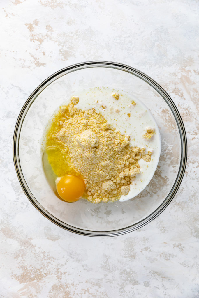 Egg, cornmeal and buttermilk in a bowl.