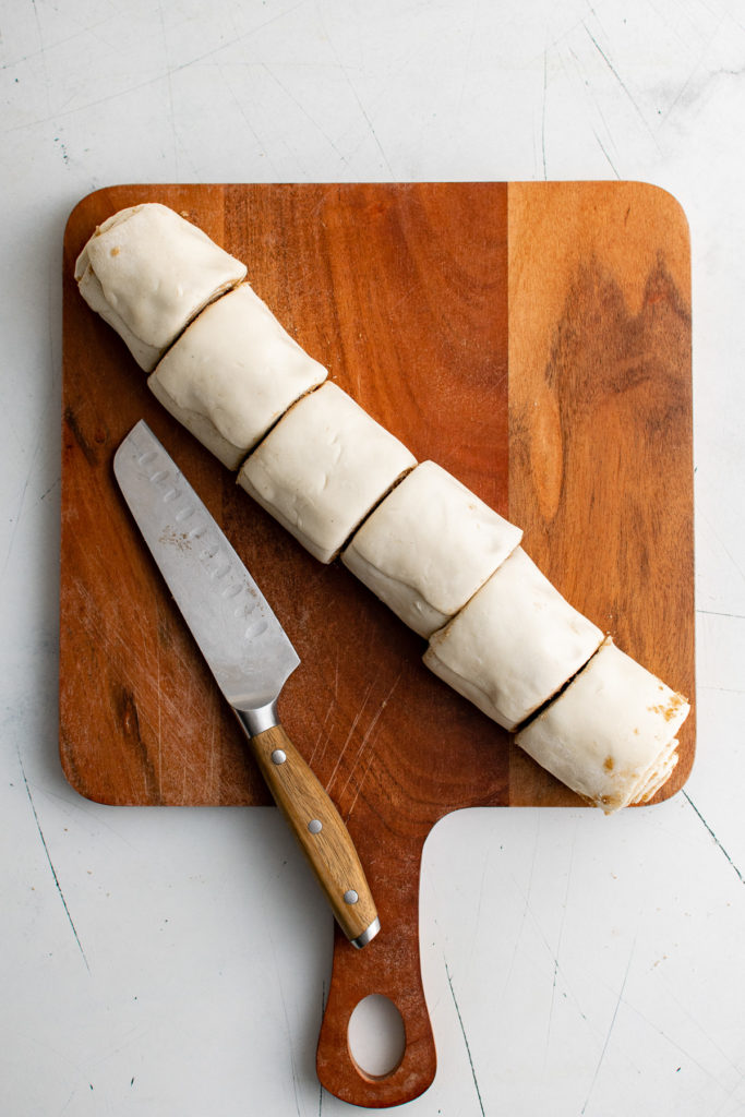 Log of puff pastry cut into individual rolls.