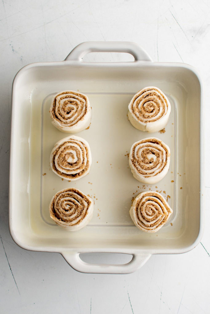 Unbaked cinnamon rolls in a pan.