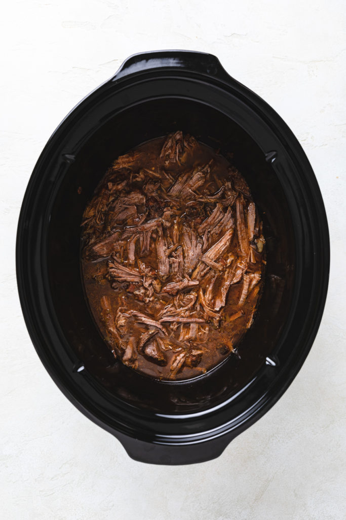 Cooked beef in a slow cooker.