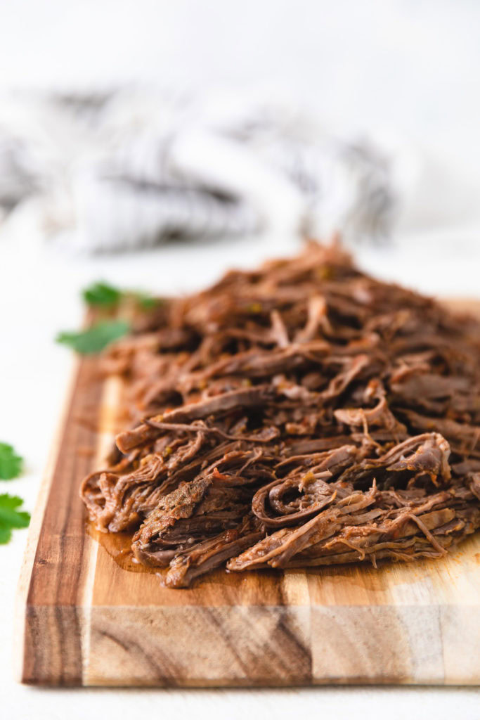 Shredded beef on a cutting board.