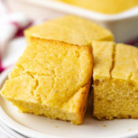 Close up view of cornbread on a white dish.