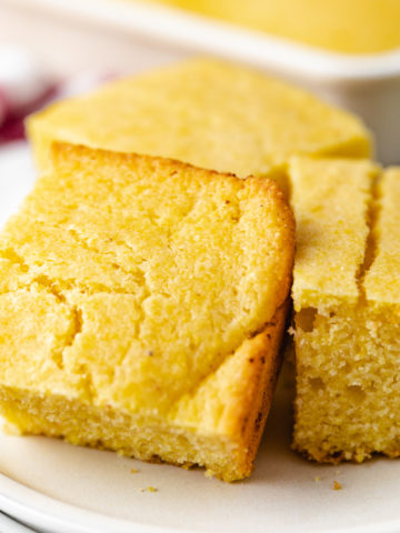 Close up view of cornbread on a white dish.