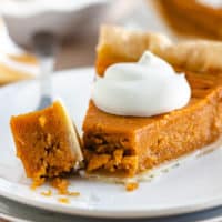 Close up view of a bite taken out of sweet potato pie.