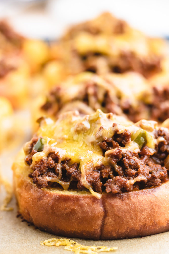 Cheese and sloppy joes on top of garlic bread.
