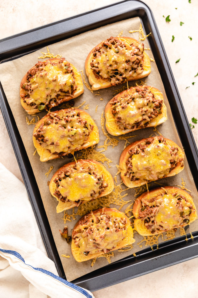Pan of texas toast with sloppy joes and melted cheese.